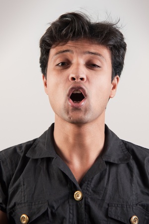 excited indian man with mouth wide open as if yelling loudlyの写真素材