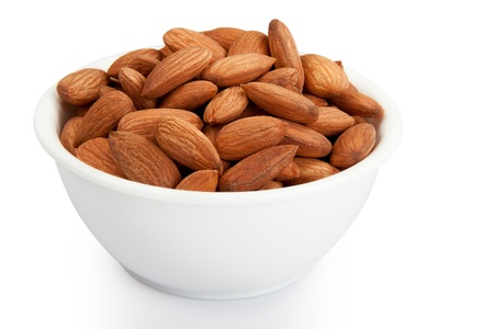 Pile of almonds in white plastic bowl isolated over white backgroundの写真素材