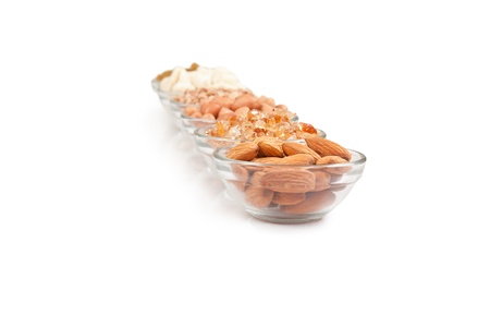 Mix collection of dry fruits in glass bowl over whiteの写真素材