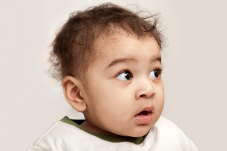 indian curious boy baby looking at the camera on white background.の写真素材