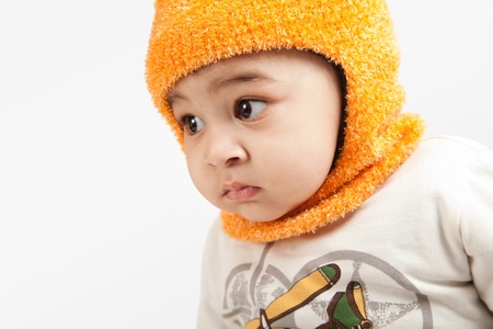 Indian curious boy baby in cap looking at the camera on white background.の写真素材