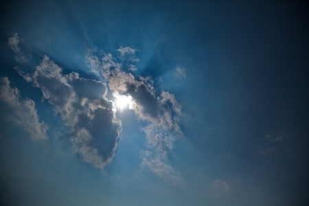 Hide and seek of sun with clouds in dark sky