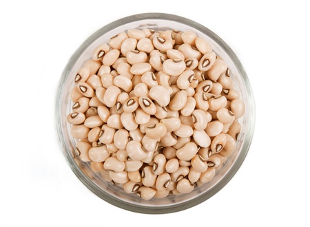 Soya beans in transparent glass bowl on white background close up view