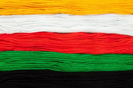 Embroidery floss laid out over black textured background