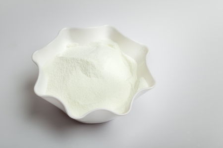 Dairy milk powder in bowl isolated over whiteの写真素材