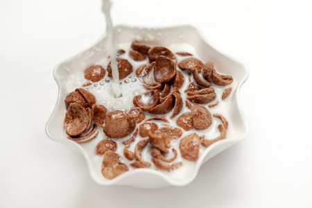 A bowl of chocolate  Corn flakes with milk isolated over white backgroundの写真素材