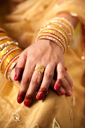 hand detail of indian bride with decorative bangle and gold ringの写真素材