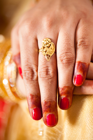 hand detail of indian bride with decorative bangle and gold ringの写真素材
