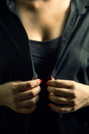 Beautiful sexy girl in black dress undressing herselfの写真素材