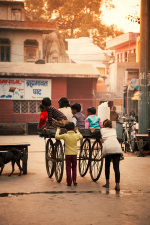 Happy Indian kids playing with wheel cart in evening at Bithoor Temple near The Bank of Ganga river...