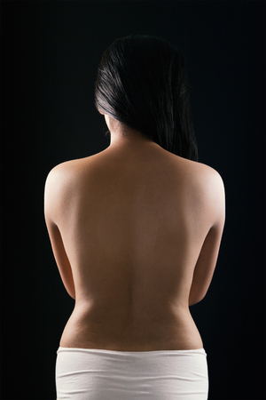 Close up sexy back of young Asian woman in white pantie isolated over black background.の写真素材