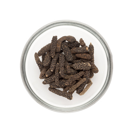 Top view of Organic Long pepper Dried Fruit Piper longum half filled in glass bowl isolated on white...