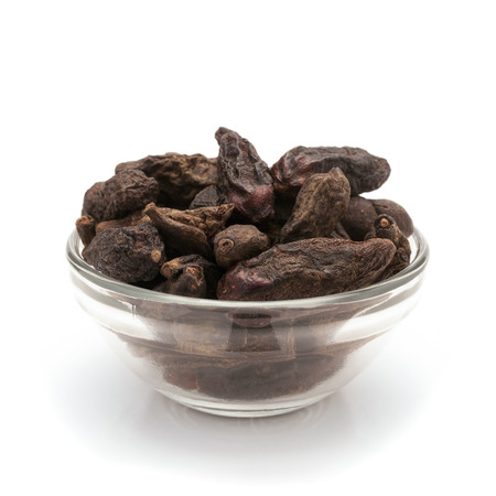 Front view of Organic Chebulic Myrobalan or Choti Harad Terminalia chebula in glass bowl isolated on white background.の写真素材