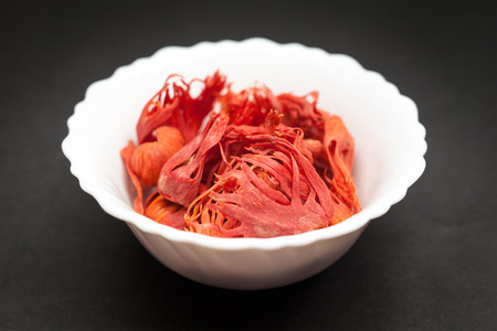 Organic Mace or jayitri Myristica fragrans in white ceramic bowl on dark background.の写真素材