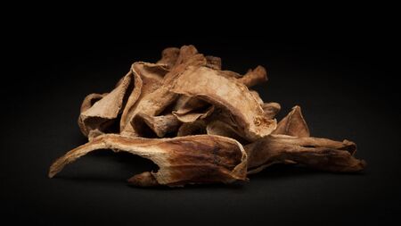 Pile of Organic Sour dried mango or Aamchur or Amchoor Mangifera indica on dark background.の写真素材