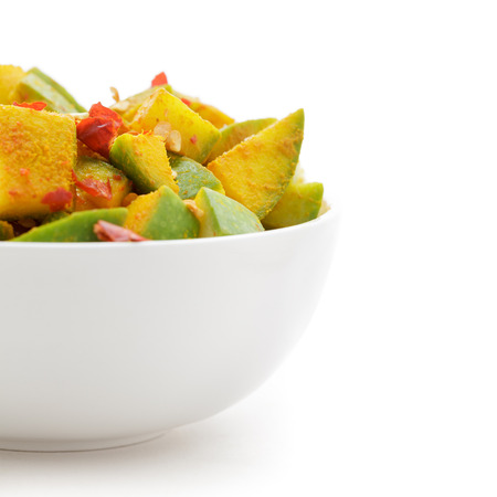 Organic sliced Indian Mango (Mangifera indica), seasoned with turmeric, salt and red chili pepper in white bowl. Isolated on white background. Front view.の写真素材