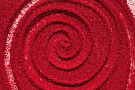 Close up spiral background texture of solid red color made of soil.