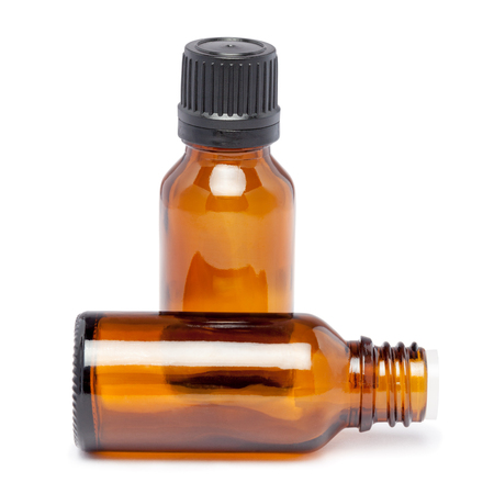Amber color small glass bottles with pin hole dropper and black cap over white backgroundの写真素材