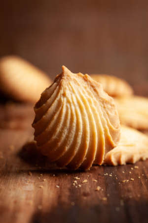 Close-up of delicious freshly baked simple cookies or biscuits. Isolated over a wooden top  background.の写真素材