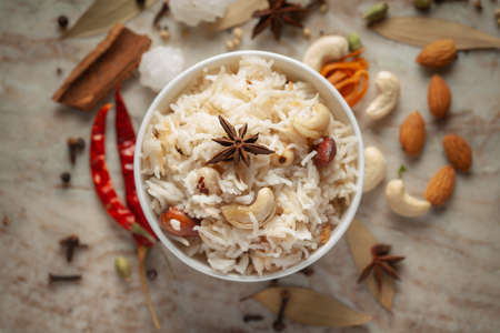 Close-up of Indian Basmati Rice or Kasmiri pulao (pulav) or Dry Fruits Pulao garnished with dry fruits and spices in a ceramic bowl.の写真素材