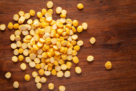 Macro Close-up of Organic Bengal Gram (Cicer arietinum) or split yellow chana dal cleaned on wooden...