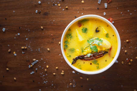 close-up of healthy curry of yogurt and potato (Dahi Aloo or Aaloo ) an Indian Classical dish. Served in white ceramic bowl. Over Wooden Background and jute mat. Top viewの写真素材
