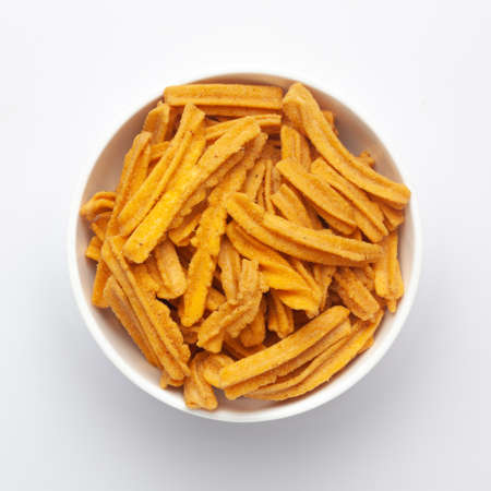 Close up of salted Soya Sticks Indian namkeen (snacks) on a ceramic white bowl. Top view