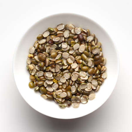 Macro Close-up of Organic split green urad dal (Vigna mungo) inside a ceramic white bowl. Top viewの写真素材