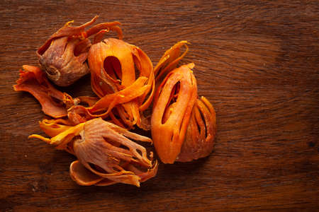 Macro close-up of Organic mace  (Myristica fragrans) on wooden top background. Pile of Indian...