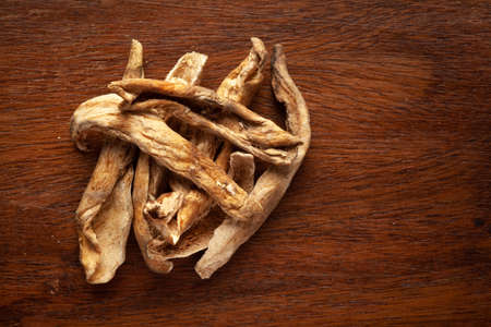 Macro close-up of Organic dried mango slices (Mangifera indica) or amchoor on wooden top background....