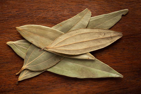 Macro close-up of Organic Indian bay leaf (Cinnamomum tamala)  tezpatta on wooden Top background. Pile of Indian Aromatic Spice. Top viewの写真素材