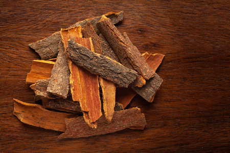 close-up of Organic cinnamon ( Cinnamomum Verum) or dalchini on wooden top background. Pile of...