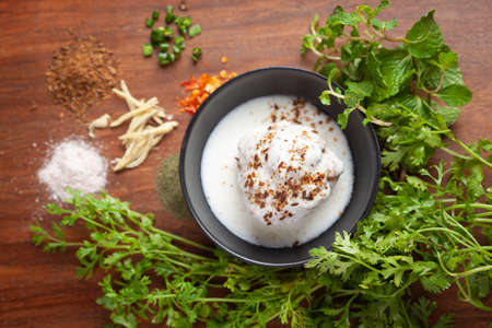 Chaat Dahi vada (AKA Dahi Bhalla, Doi Bora, mosaru vade, Dahi Bara, thayir vadai, perugu vada). Prepared by soaking vadas in thick curd (yogurt). Garnished with cumin and green fresh corianderの写真素材