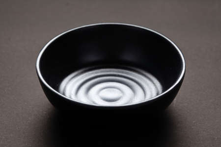 An empty ceramic black bowl for mockup. over black backgroundの写真素材
