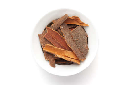 Macro close-up of Organic cinnamon ( Cinnamomum verum) or dalchini on white background. Pile of...