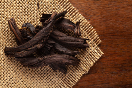 Macro close-up of Organic Alkanna tinctoria or ratan jot on the wooden top background and jute mat....