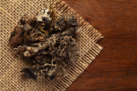 Macro close-up of Organic  Kalpasi or Dagad phool or black stone flower or chhabila on the wooden top background and jute mat. Pile of Indian Aromatic Spice. Top viewの写真素材
