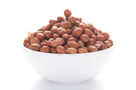 Close up of organic red brown peanuts (Arachis hypogaea) inside a white Ceramic bowl,