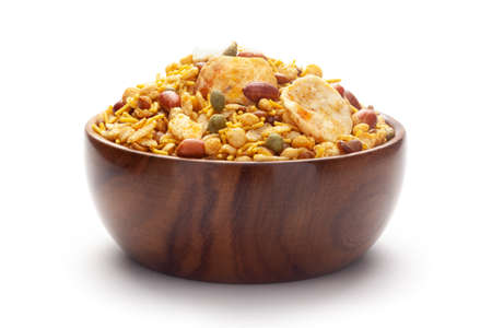 Close-Up of Hot spicy Nav Ratan snacks In hand-made (handcrafted) wooden bowl, made with red chili, peanuts. Indian spicy snacks (Namkeen),の写真素材