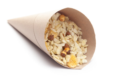 Close-Up of Crunchy Diet Mixture In handmade ( handcraft ) brown paper cone bag made with Puffed Rice, Corn Flakes, and Curry leaves. Indian spicy snacks (Namkeen),の写真素材