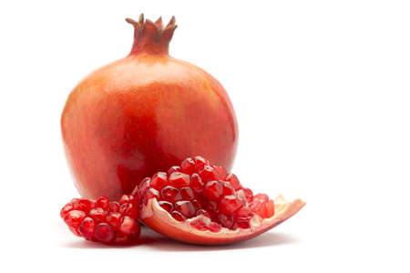 Close-up of organic red pomegranate and a section of it  (Punica granatum) isolated over white background.の写真素材