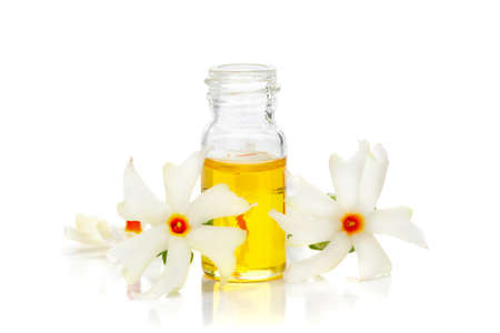 Micro close-up of Essential Oil or Attar, Fragrance Oil, Perfume oil in mini transparent glass bottle of orange small night blooming flower Parijat or Harshringar (Nyctanthes arbor-tristis)の写真素材