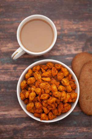 Close-Up of crunchy Indian mixture snacks with hot tea or Coffee time and handmade cookies...