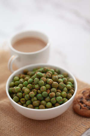 Close-Up of crunchy Indian mixture snacks with hot tea or Coffee time and handmade cookies (biscuits). Studio shoot at declined angle.の写真素材