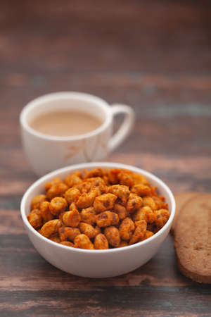 Close-Up of crunchy Indian mixture snacks with hot tea or Coffee time and handmade cookies (biscuits). Studio shoot at declined angle.の写真素材