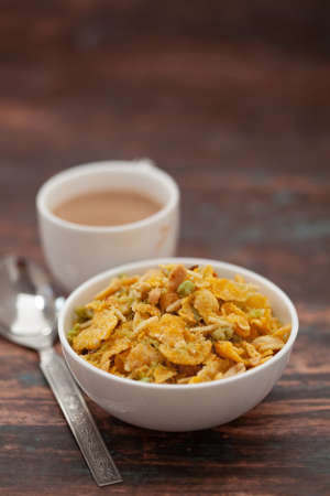 Close-Up of crunchy Indian mixture snacks with hot tea or Coffee time and handmade cookies (biscuits). Studio shoot at declined angle.の写真素材