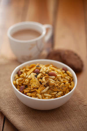 Close-Up of crunchy Indian mixture snacks with hot tea or Coffee time and handmade cookies (biscuits). Studio shoot at declined angle.の写真素材