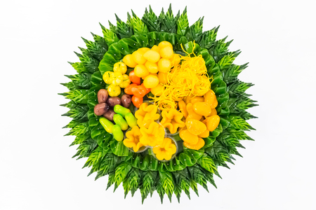 Thai dessert (Khanom Thai), colorful appearance and distinct flavors with handcraft of banana leaf on white backgroundの写真素材