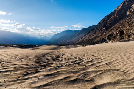 Wave on sand dunes foreground with mountains and blue sky background - Nubra valley, Leh, Ladakh, Jammu and Kashmir, Northern Indiaの写真素材