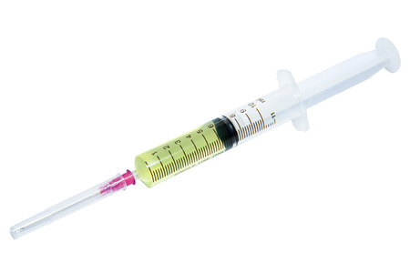 Isolated plastic syringe with yellow liquid on white backgroundの写真素材